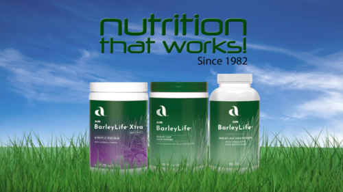 A green grassy field with three barley life bottles with text that reads Nutrition that works since 1982 