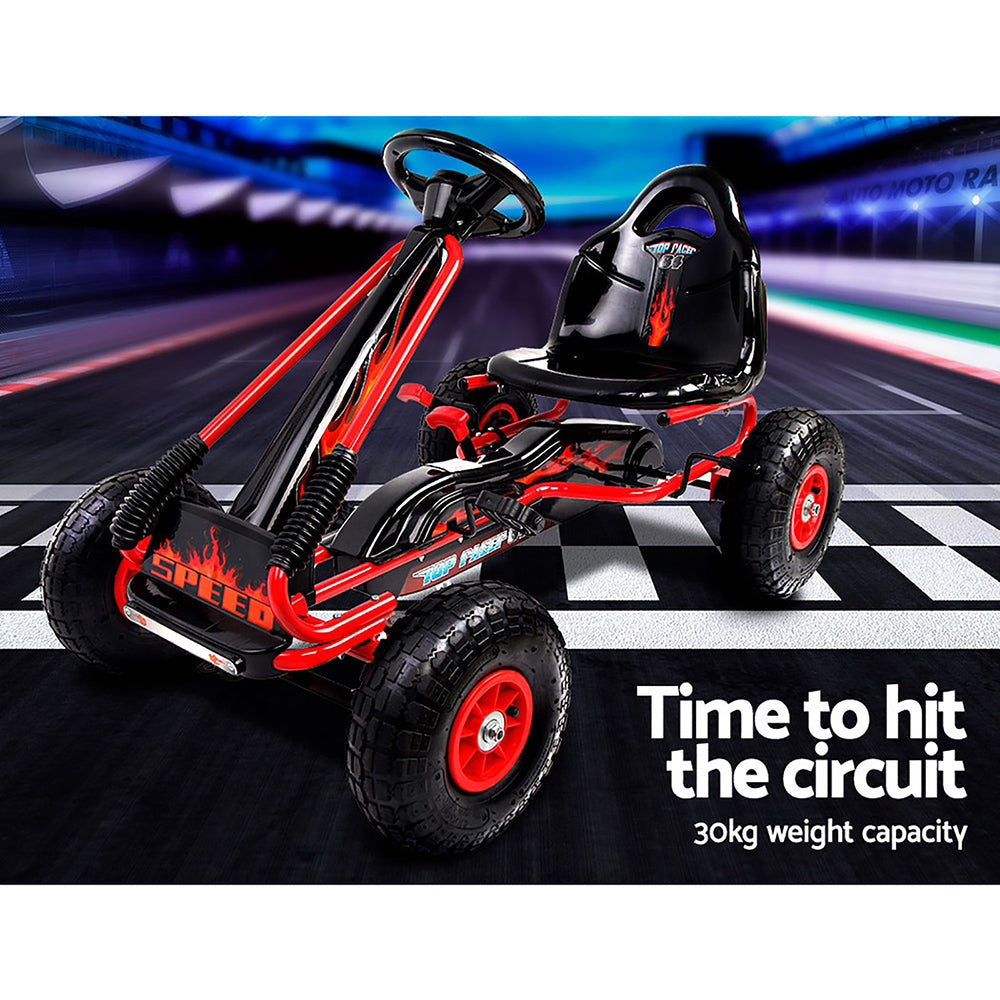 A hot red and black coloured pedal powered childs Go-cart with a race track background.